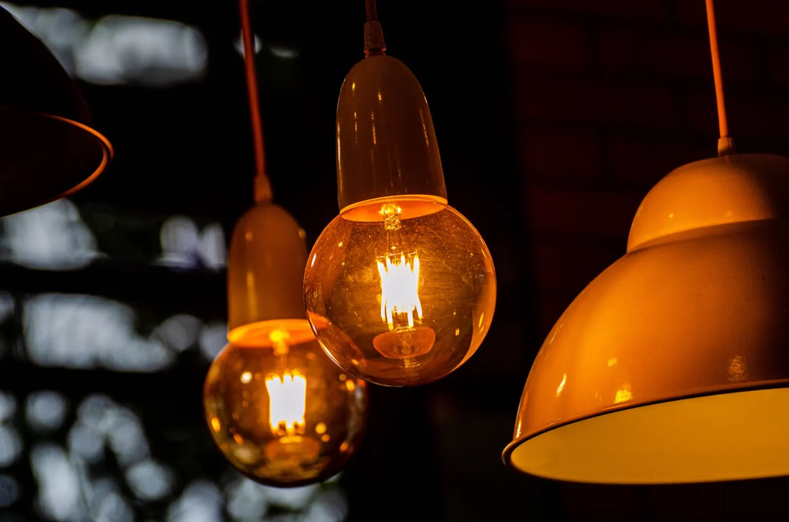 Warm amber filament bulbs hanging in a dark café