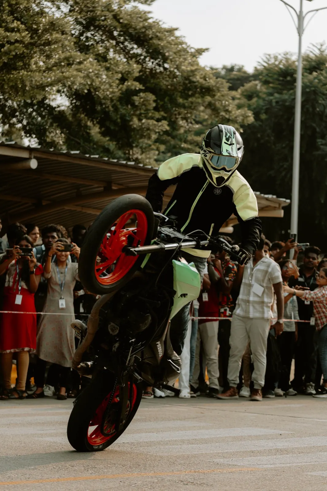 Rider pulling a wheelie in front of a watching crowd