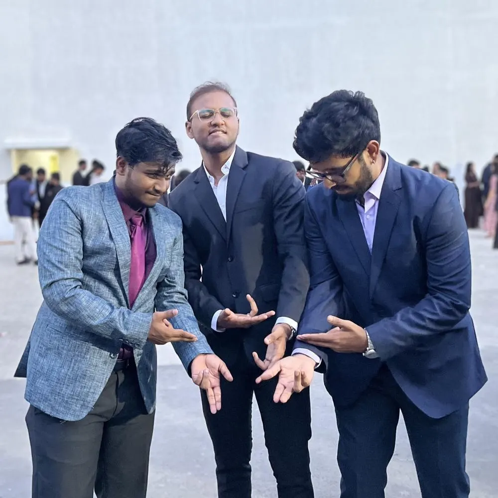Polaroid of Balaji, Aro and JD in suits